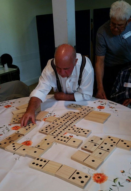 Alfonso playing dominoes at Sha'arei Tsedek in a Dementia Club UK session