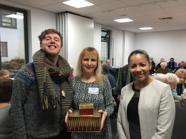 Steven and Juliana from Carlton Court Care Home with Lisa holding a box of home made cookies