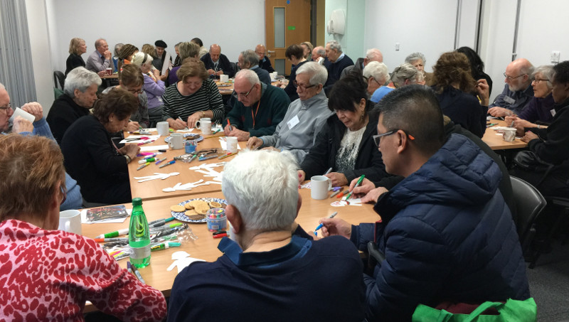 Members of Dementia Club UK busy colouring in figures for the banner