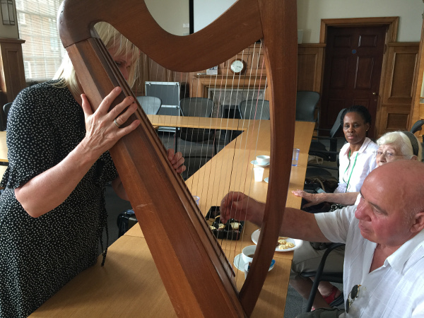 Helen showing the red strings on her harp to the some of the members of Dementia Club UK