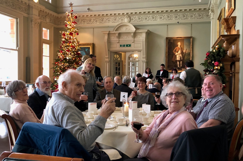 Members in the 'Long Room' listening to carol singers and enjoying their tea.