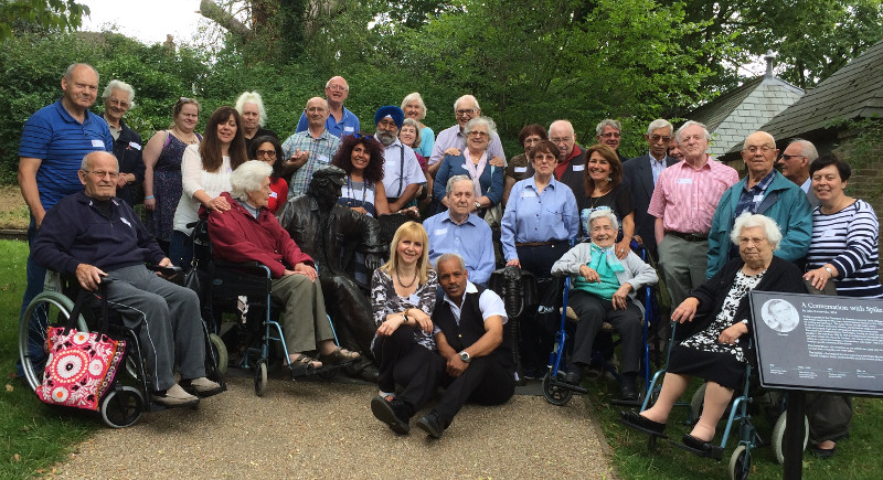 Group photo of members with statue of Spike Milligan at Stephens House